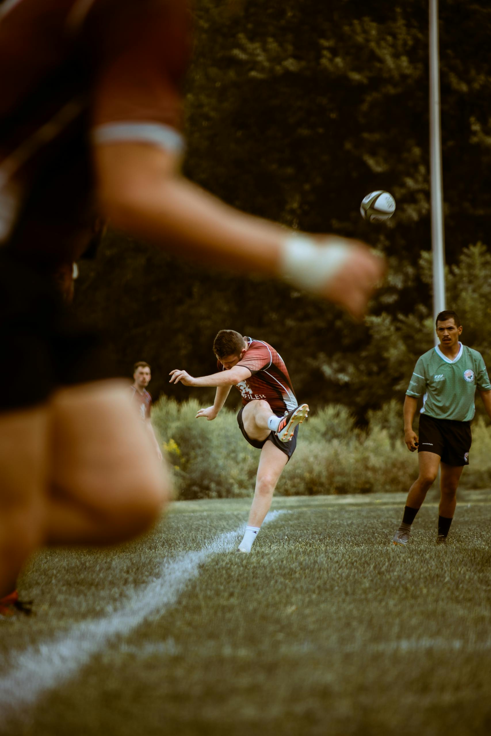 Rugby player kicking off a match. Illustrating the question, do rugby scrum caps prevent concussions? And why head protection research matters in rugby.